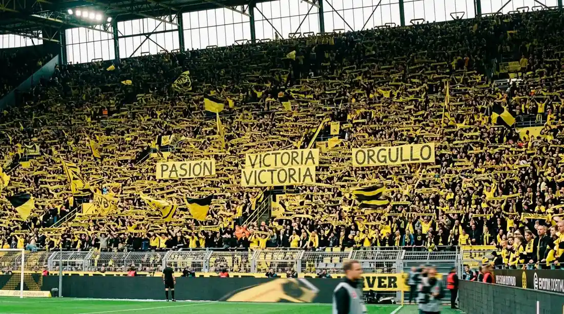 Muro amarillo del Signal Iduna Park lleno de aficionados del Borussia Dortmund durante un partido de Bundesliga